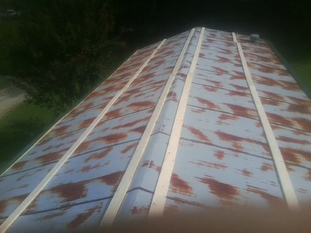 Rusted metal roof panels with new wood purlins before replacement — Storm Damage Roof Repair in Hazleton by Roofing Brothers