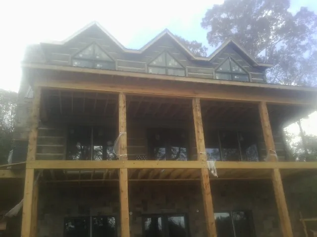 Dormers and porch framing on a large log home under construction — Roof Coating work by our crew in Hazleton