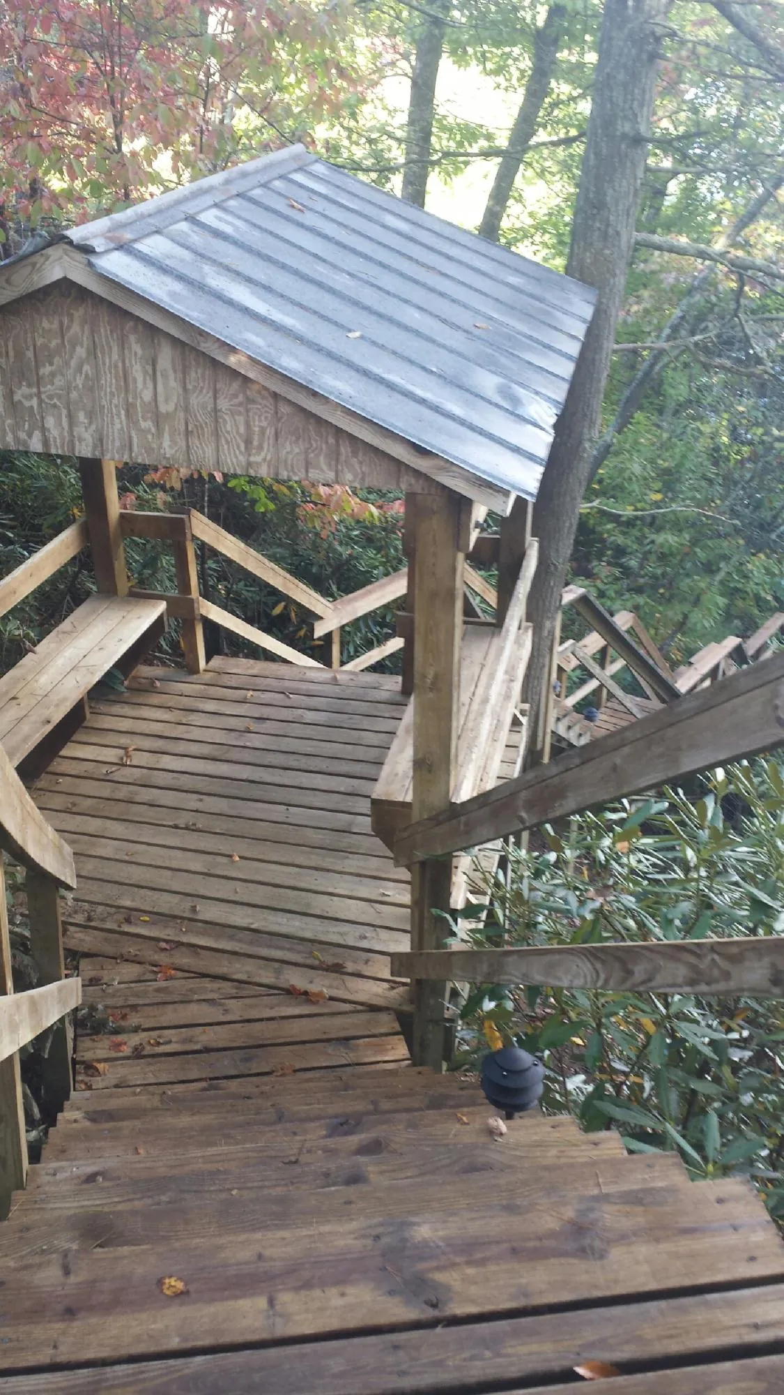 Metal roofed shelter over wooden steps on a wooded walkway — Skylight Repair & Installation work by our crew in Hazleton