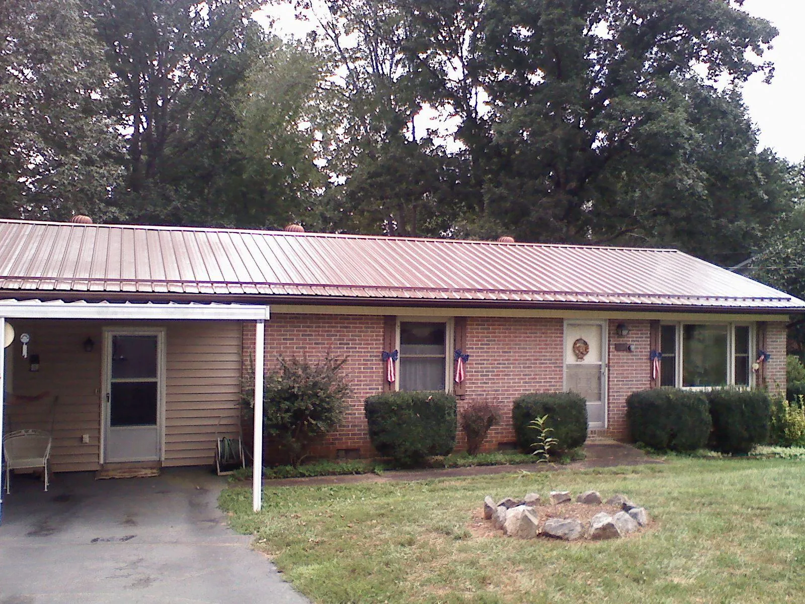 Bronze metal roof and carport on a brick ranch home — Roof Repair work by our crew in Hazleton